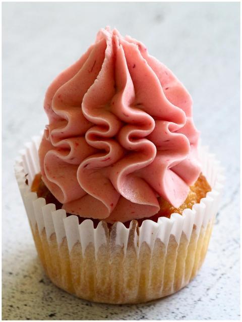 A pink frosted cupcake, perfect for dessert lovers