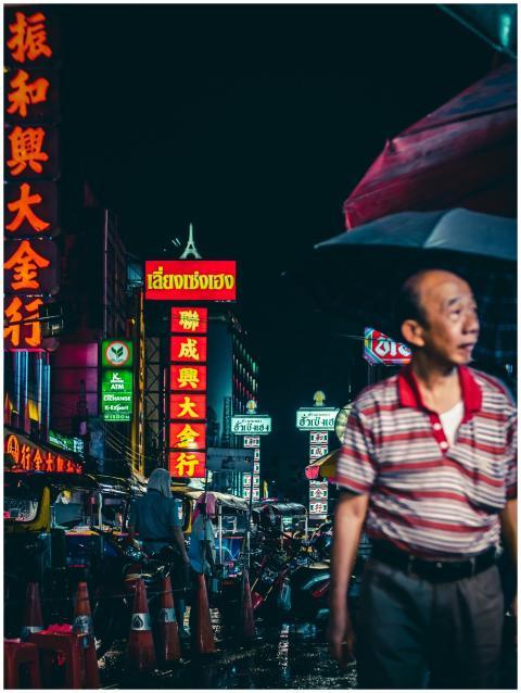 Lively urban scene with neon signs and people unde