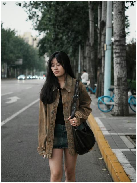 Woman in casual outfit strolling along an urban tr