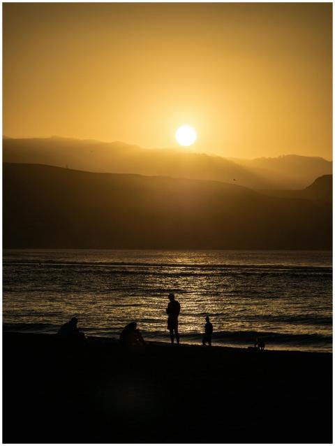 A serene sunset scene with silhouettes of people a