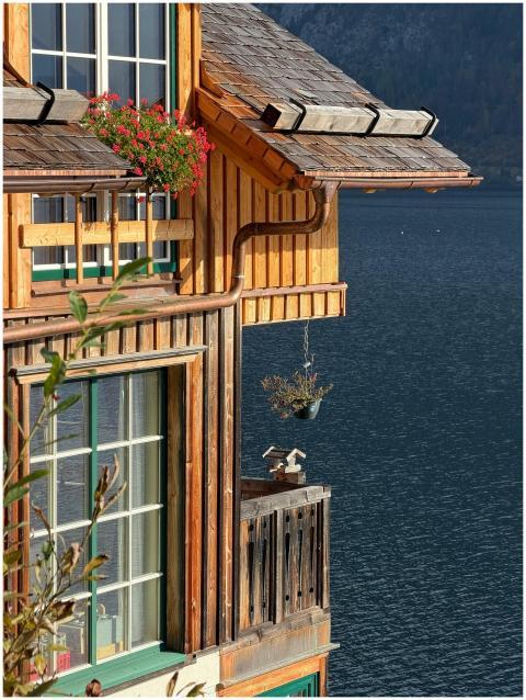 Charming wooden lakeside house with flowers in pic