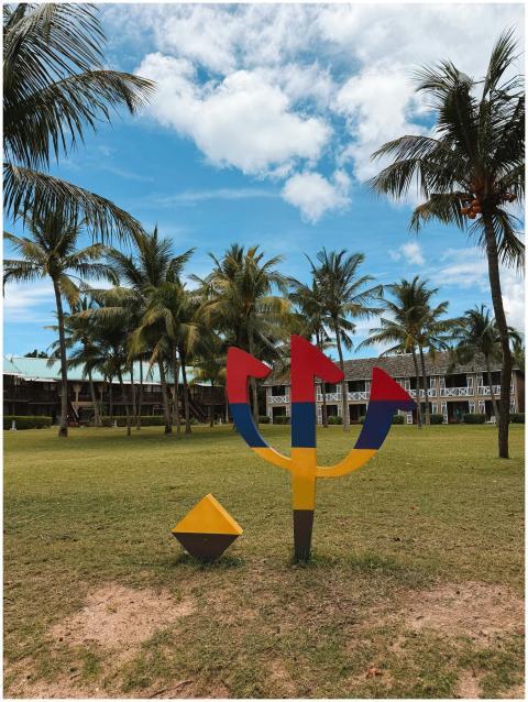 Colorful sculpture against tropical palm trees and