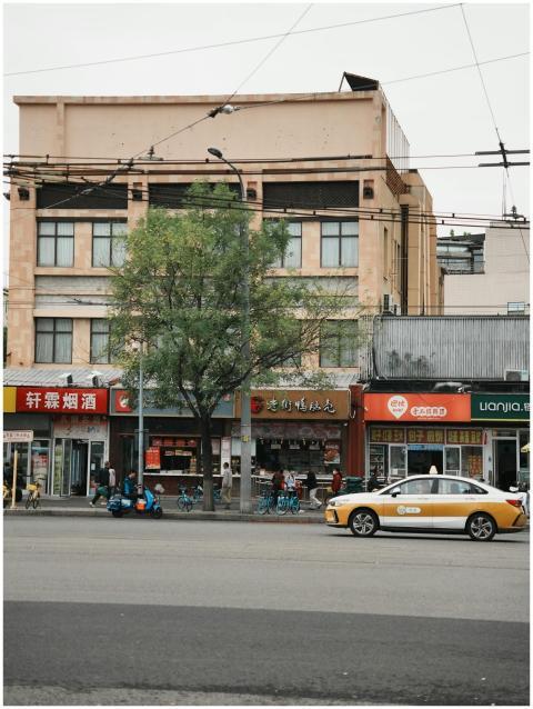 Vibrant city street with local shops, a tree, and