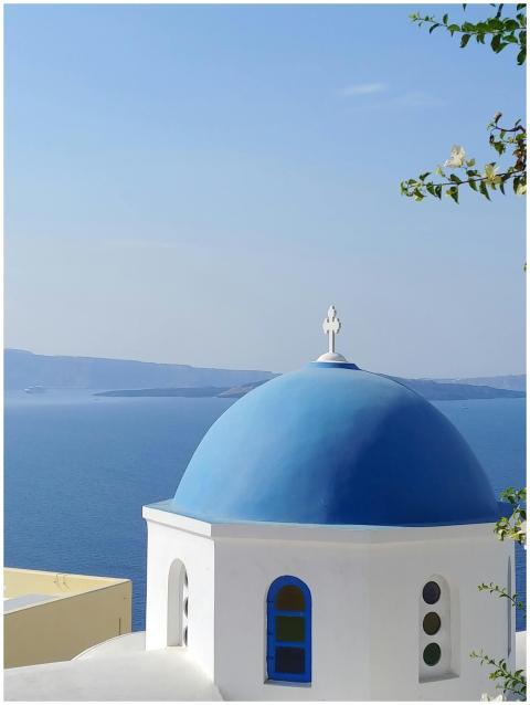 Iconic blue-domed church in Santorini with a clear