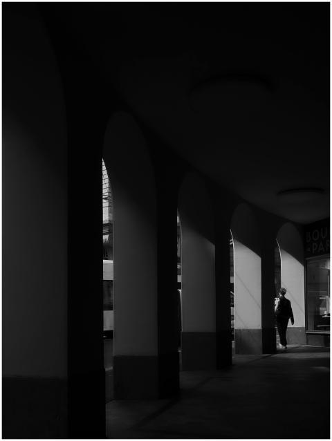 Moody black and white photo of an archway with a s
