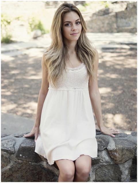 Portrait of a young woman in a white dress sitting