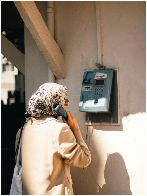 A Muslim woman in hijab stands at an outdoor vinta