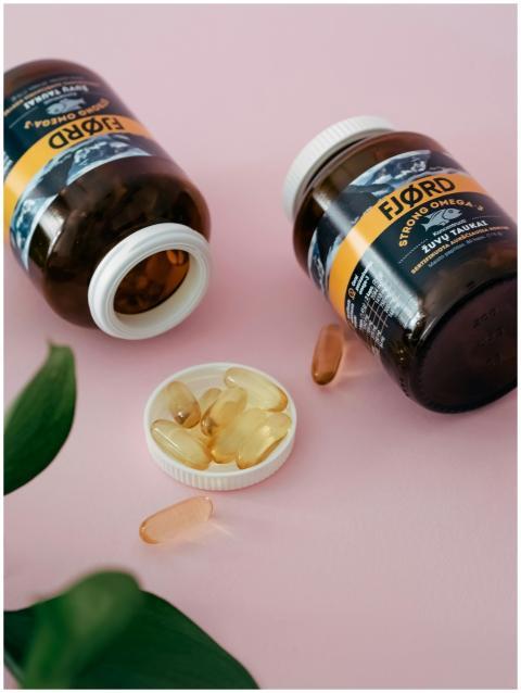 Close-up of omega 3 supplement bottles and capsule