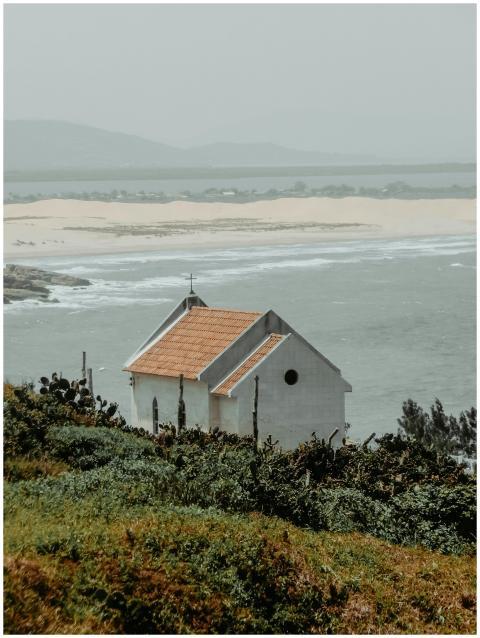 A small white chapel overlooking the ocean, surrou