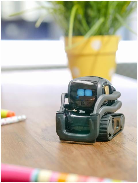 Close-up of a small robot toy on a desk, represent