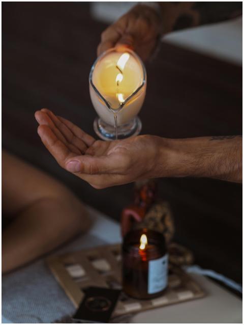 Serene indoor scene of candle massage oil being po