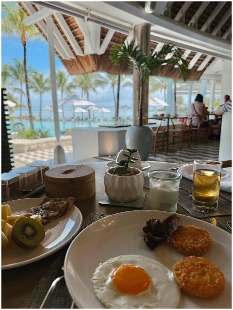 Tropical breakfast with fried egg, fruits, and bea