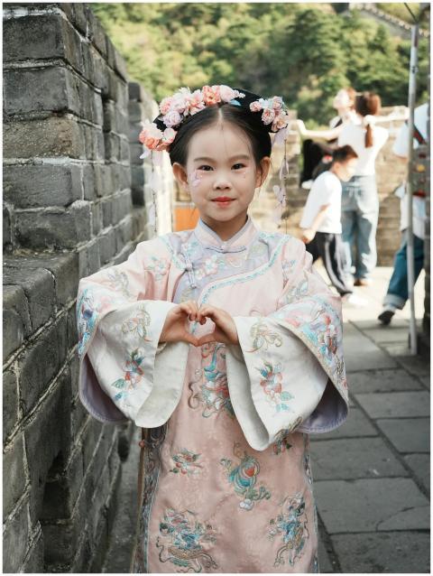 A young girl wearing traditional Chinese attire st