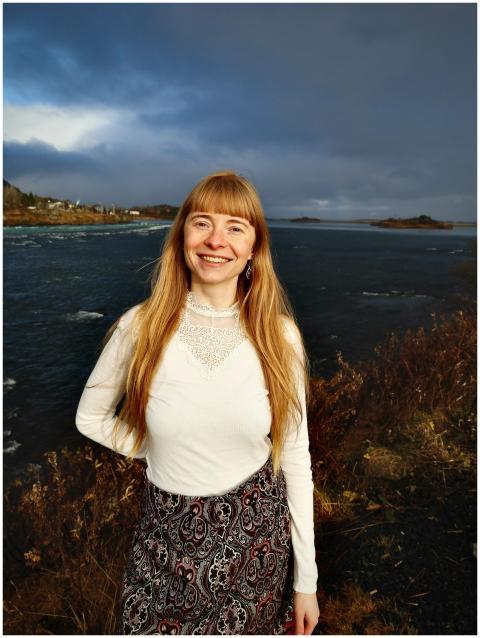 A happy woman in white blouse and skirt enjoys the