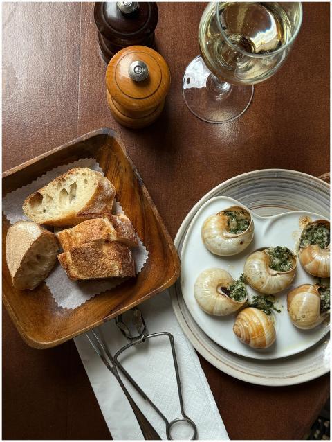 Gourmet dining setup featuring escargot, bread, an