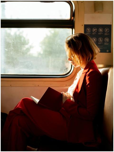Caucasian woman reading a book on a train during t