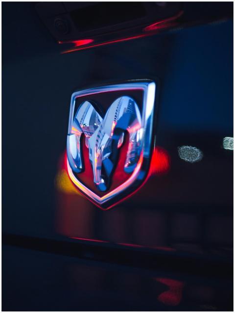 Close-up of a chrome Dodge Ram emblem with neon bo