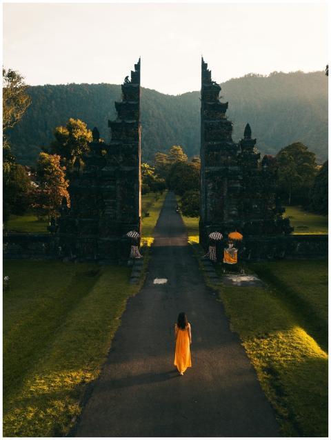 Aerial view of a woman in orange dress walking tow