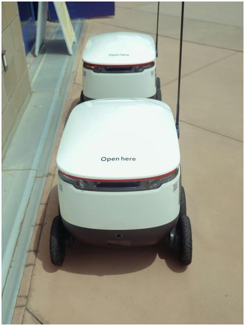 Futuristic delivery robots parked, showcasing mode