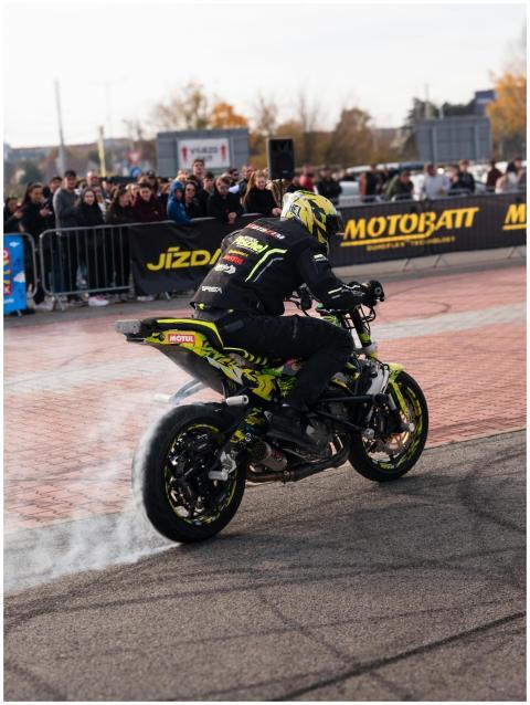 Motorcycle stunt show in action, with a rider perf