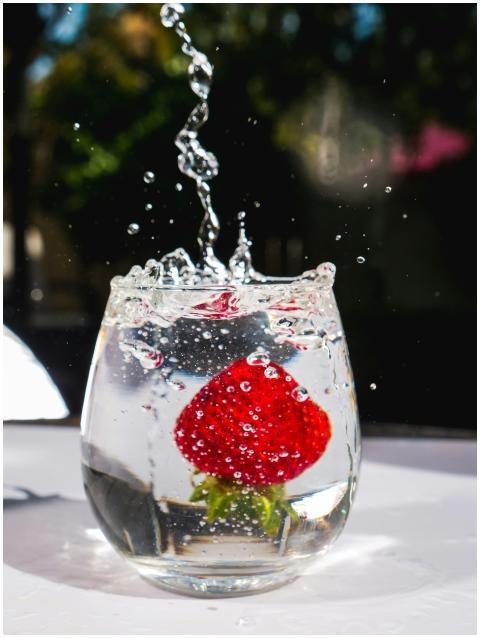 A vibrant splash as a fresh strawberry drops into