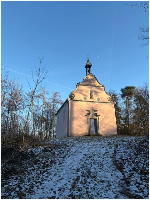 Serene chapel set in a snowy forest under a clear