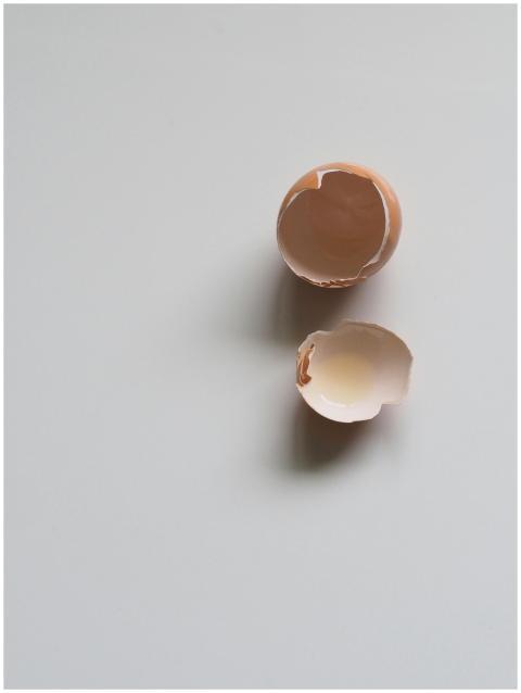 A top-down view of a broken eggshell on a minimali