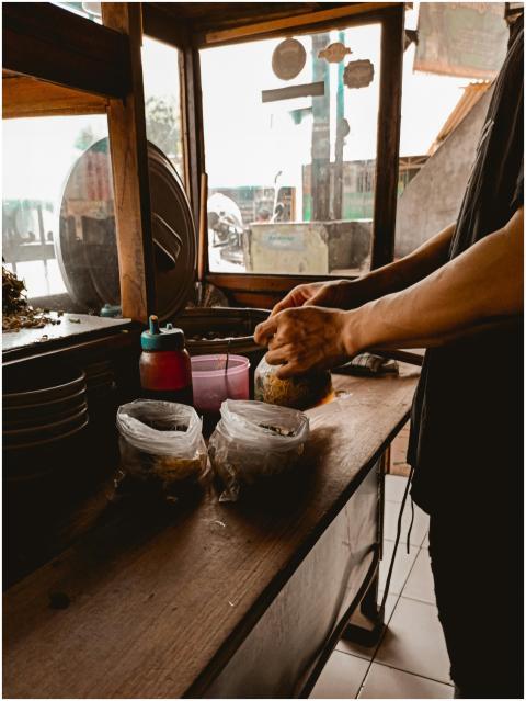 Side view of crop anonymous male cook working at c