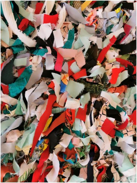 A vibrant collage of fabric scraps creates a color