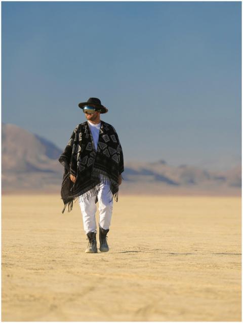 A stylish adult walks through the desert in Ras Al