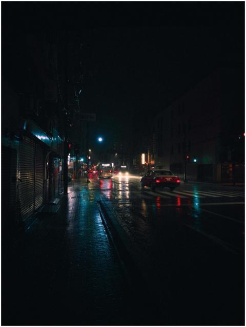 Illuminated rainy street in Kyoto at night, reflec