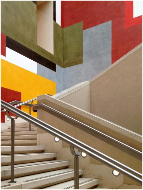 A modern indoor staircase with vibrant geometric w