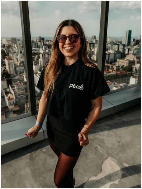 A smiling woman in sunglasses enjoys a panoramic v