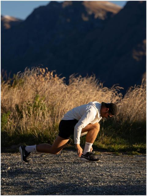 Athlete in sunset light, ready to sprint outdoors