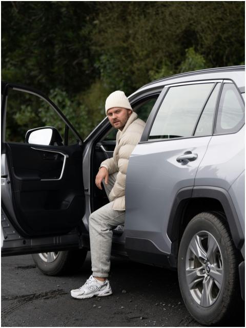 A man sitting in an open SUV door in Kaikoura, New