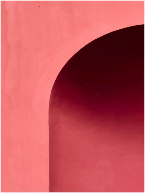 A close-up of a curved pink arch showcasing minima
