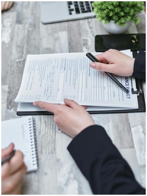 Close-up of hands analyzing insurance policy paper