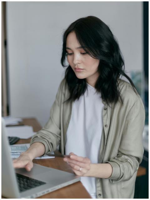 Focused young woman working on a laptop at her des