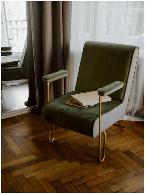 Stylish green armchair with gold legs in a contemp