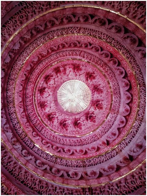 A vibrant pink circular ceiling with intricate geo