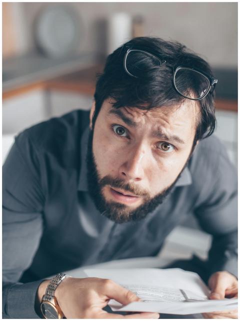 Portrait of an astonished man with a beard holding