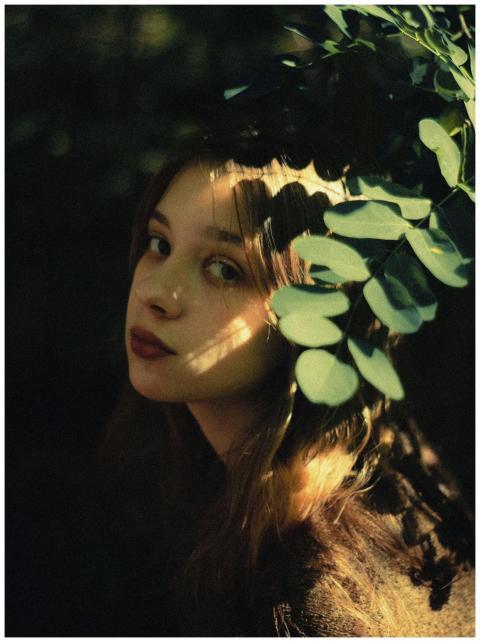 Portrait of a young woman with sunlight and leaf s