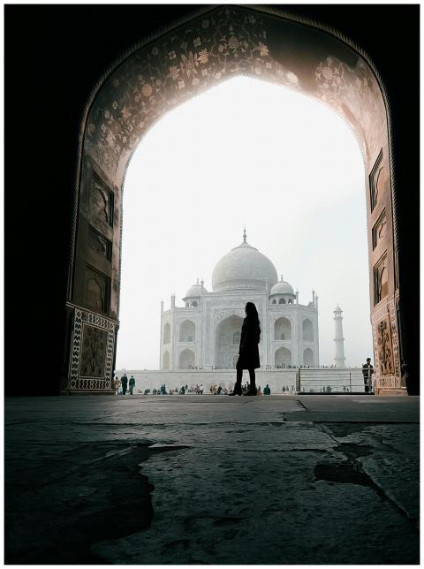 A traveler silhouetted at the grand entrance of th