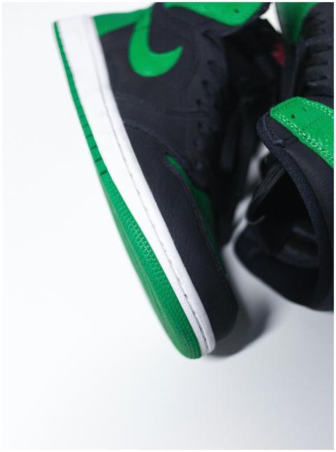 Detailed close-up of black and green sneakers disp