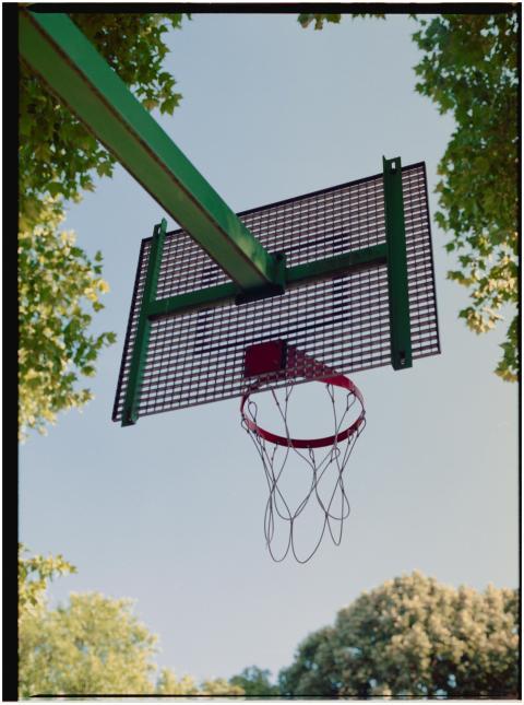 Photograph of an outdoor basketball hoop with a cl