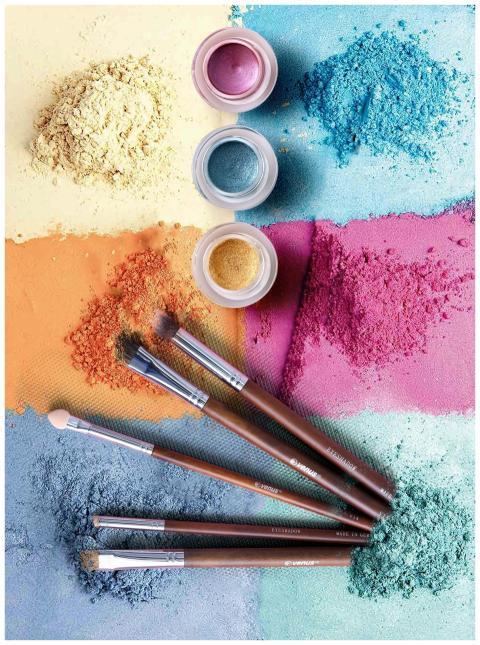 Colorful makeup powders and brushes in an artistic