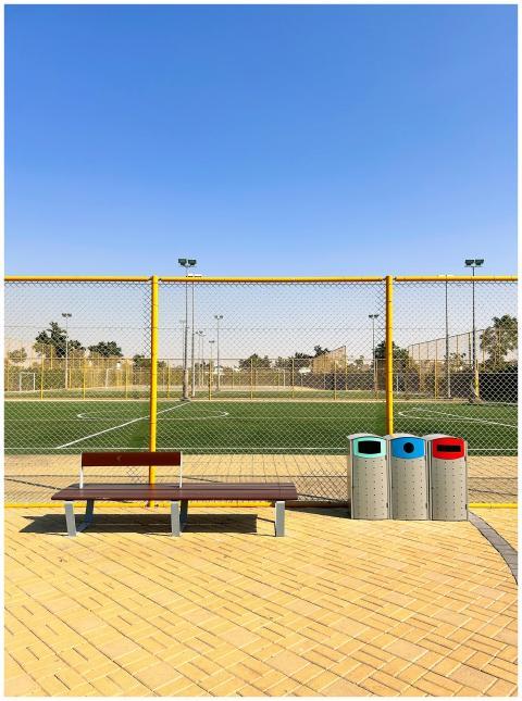 A bright day at a Dubai soccer field showing bench