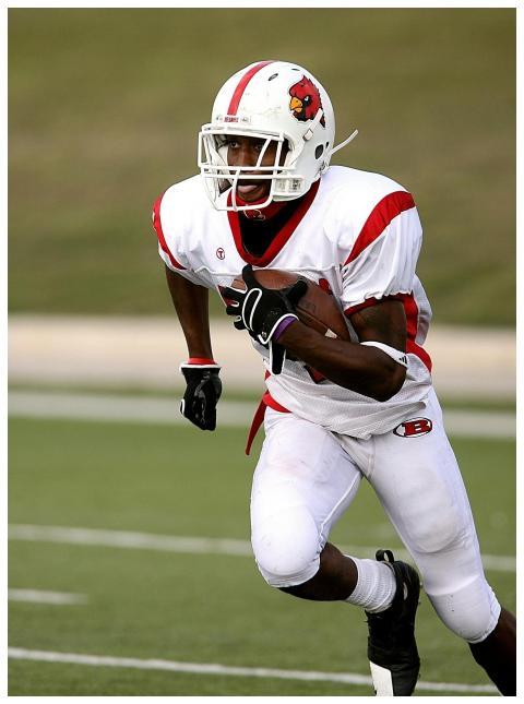 A football player in uniform running on the field