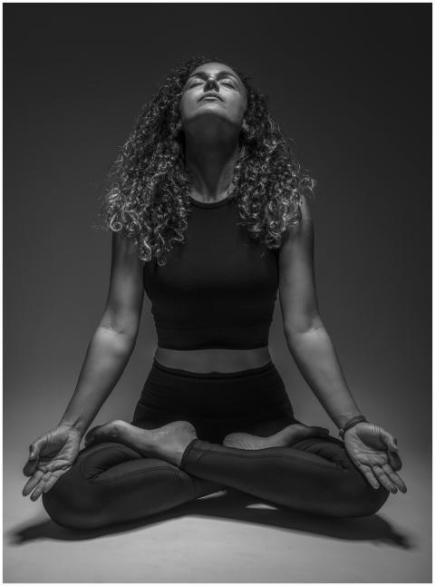 Serene woman practicing yoga meditation in black a