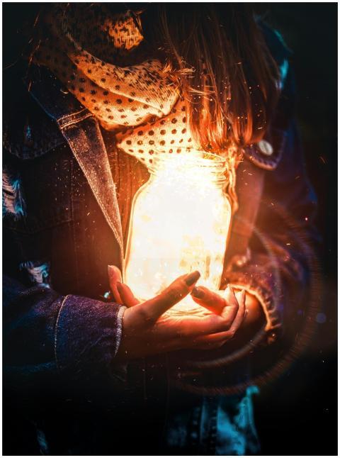 Artistic portrait of a woman holding a glowing jar